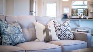 Un salon avec un canapé et des coussins à motifs.