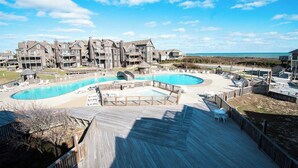 A resort with a large pool area, multiple decks, and a view of the beach. - 1BR Coastal Condo w/ Pool Access (Kitty Hawk)