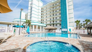 A hotel with a large pool area, multiple balconies, and a tropical theme.