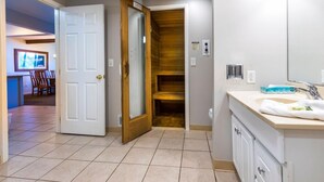 Une salle de bain avec un lavabo, un miroir et un mur recouvert de panneaux en bois.