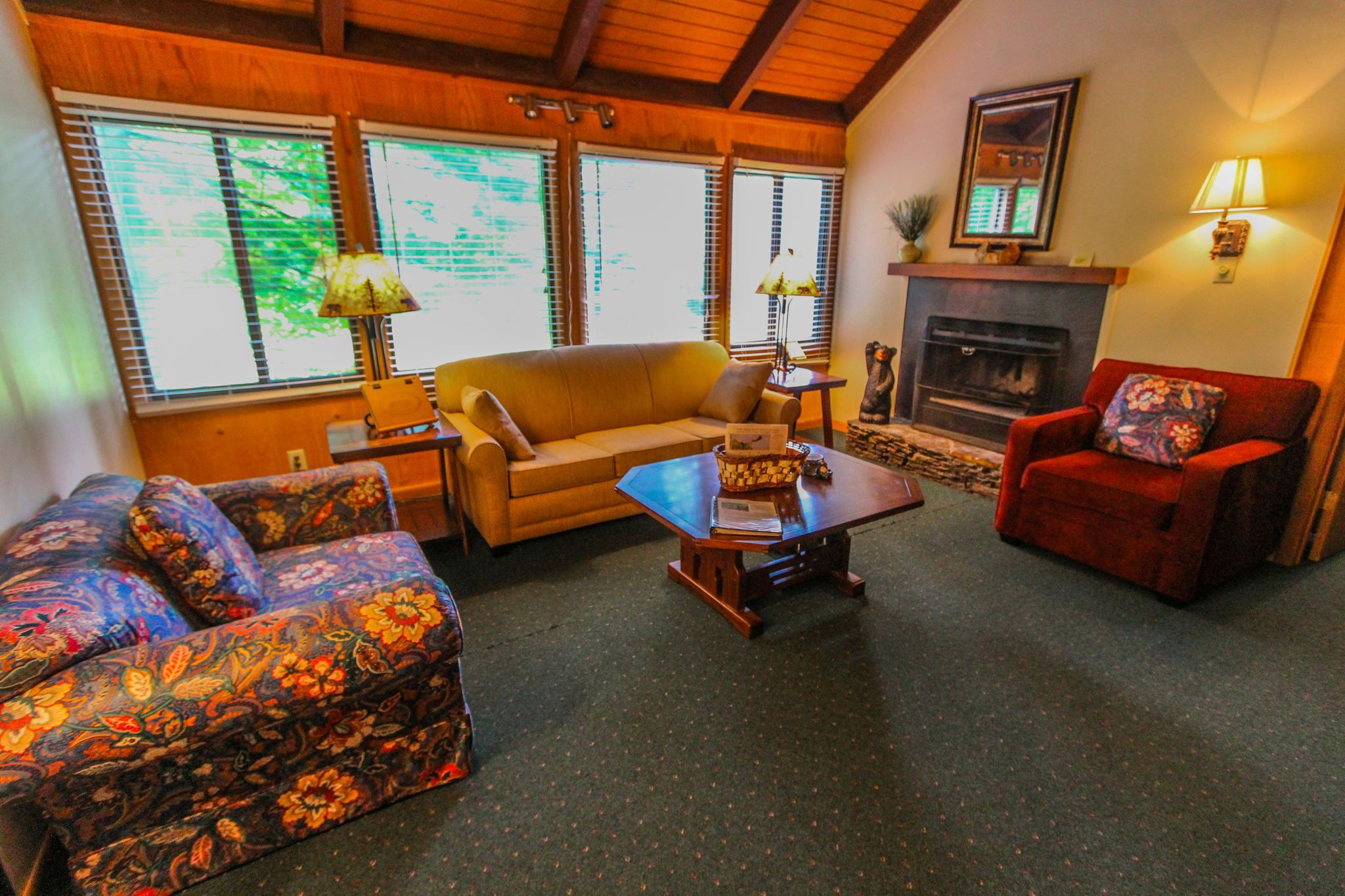 A cozy living room with a sofa, armchair, and a small table with a lamp.