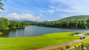A golf course with a lake, surrounded by forested hills. - Mountain Condo w/ Deck & Fireplace (Marble Hill)