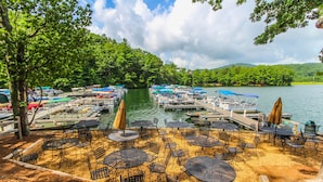 A lakeside dock with boats, tables, and chairs for outdoor dining. - Mountain Condo w/ Deck & Fireplace (Marble Hill)
