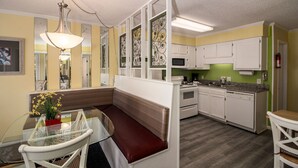 A compact kitchen with white cabinets, a microwave, and a built-in oven.