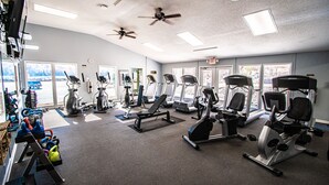 A gym with various exercise equipment, large windows, and ceiling fans. - Mountain Getaway | Pools, Trails & More! (Lake Lure)