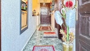 A hallway with a marble floor, a red patterned rug, and a decorative vase with flowers. - 2-bedroom villa in fabulous Marrakech with WiFi, AC (Marrakech)
