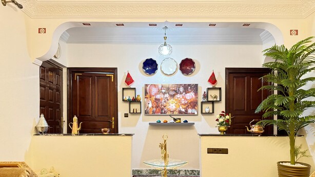 A lobby with a marble coffee table, a large painting, and a potted plant. - 2-bedroom villa in fabulous Marrakech with WiFi, AC (Marrakech)