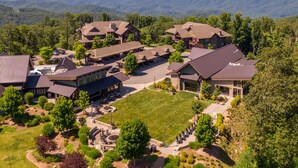 A resort with multiple buildings, a central courtyard, and a mountainous backdrop. - Calico Haven at BRMC | Hot Tub, Views, Pool (Boone)
