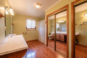 Une salle de bain avec un grand miroir, un lavabo et des toilettes.
