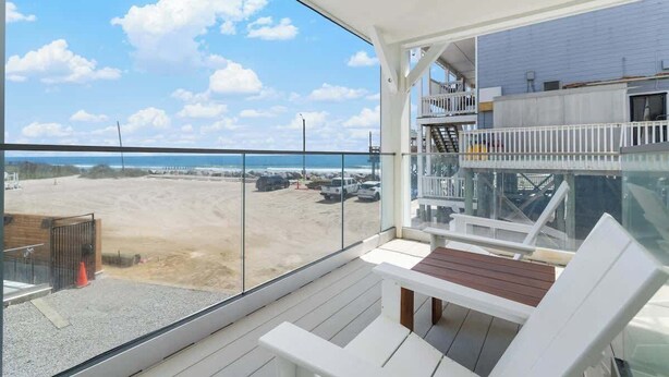 Un balcón con vista a la playa y al estacionamiento.