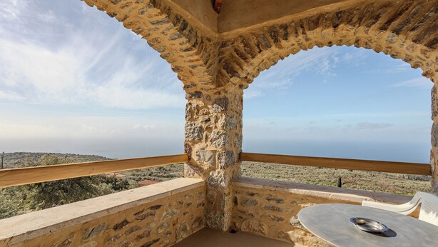 A stone balcony with a table and chairs, overlooking a hilly landscape. - Charming 2-bedroom apartment with WiFi, AC in lovely Nomitsi (Nomitsi)
