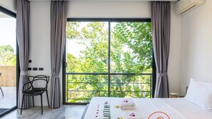 A hotel room with a large window, a bed, a chair, and a small table. - Experience serene sea views, private pool, and tropical luxury in this stunning 3-bedroom villa. (Ko Samui District)