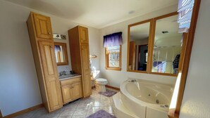 A bathroom with wooden cabinets, a sink, a toilet, a bathtub, and a window with curtains. - Hiking,canoeing,fishing,close to atv,utv trails (Madrid)