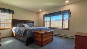 A bedroom with a bed, a wooden dresser, and a window with a view of the outdoors. - Hiking,canoeing,fishing,close to atv,utv trails (Madrid)