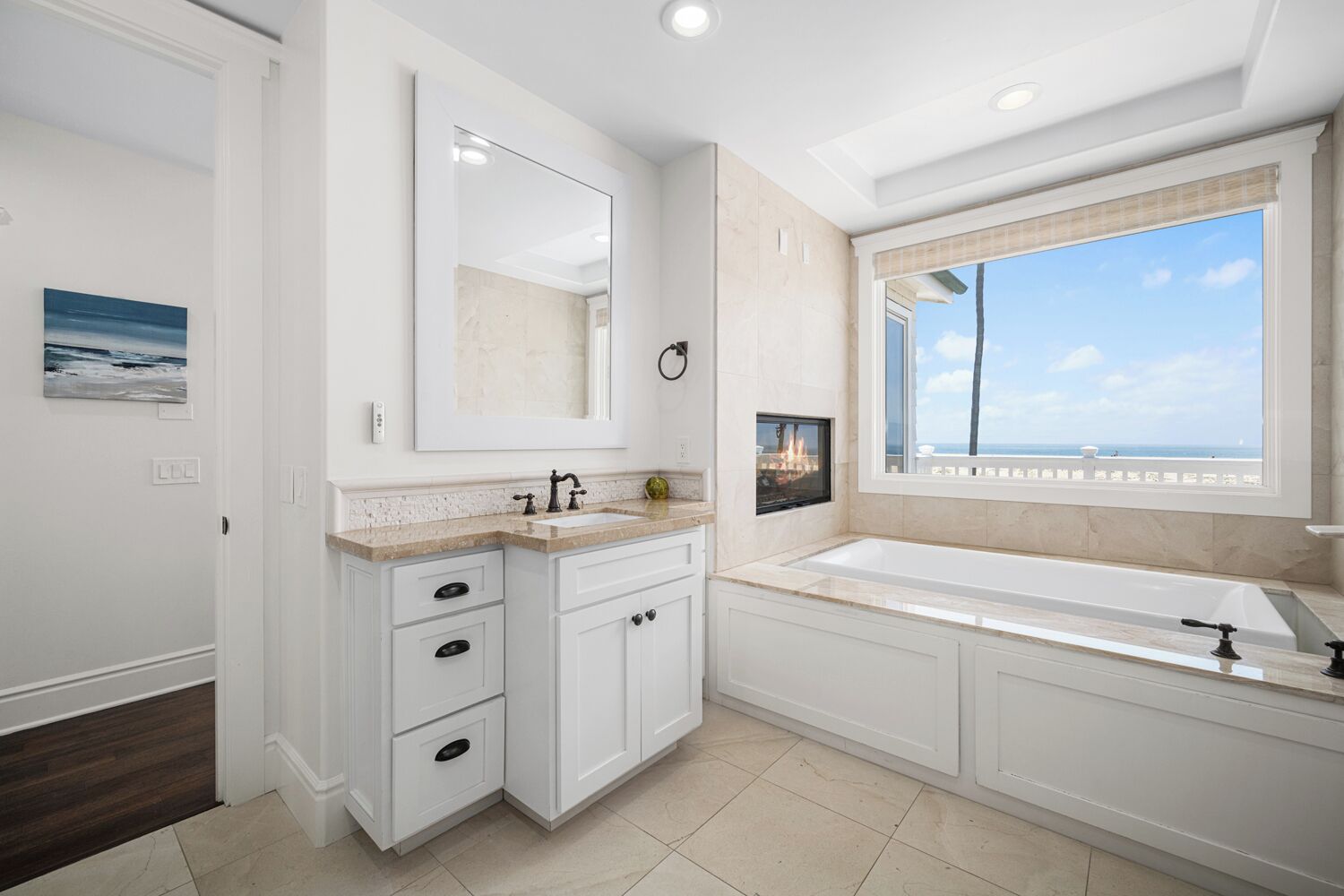 Une salle de bain moderne dotée d’une grande fenêtre, d’une cheminée intégrée et d’un meuble-lavabo double.