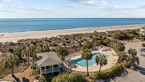 Une propriété située en bord de mer, dotée d’une piscine, d’une plage et offrant une vue sur l’océan.