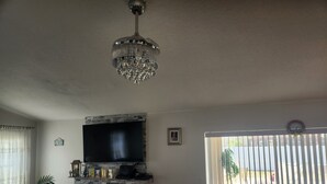 A living room with a fireplace, a ceiling fan, and a view through a sliding door. - 3-bedroom house in marvelous New Port Richey with WiFi, AC (New Port Richey)