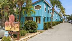 Ein blaues Gebäude mit einem Schild für 'Sand Dune Shores Resort'.