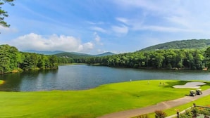 A golf course with a lake, surrounded by dense forest and hills. - Scenic Getaway in Jasper Mountains (Marble Hill)