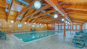 An indoor swimming pool with wooden beams and tiled flooring.