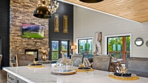 A modern kitchen with a marble countertop, decorative centerpieces, and a stone wall.