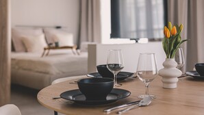 A dining table set with black bowls, wine glasses, and cutlery, with a vase of tulips on the table. - Casa Przestronne Studio z Balkonem Klimatyzacja Opera Nova Star wka (Bydgoszcz)