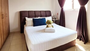 Une chambre d’hôtel avec un lit, un ventilateur de plafond, une fenêtre avec des rideaux et une armoire en bois.