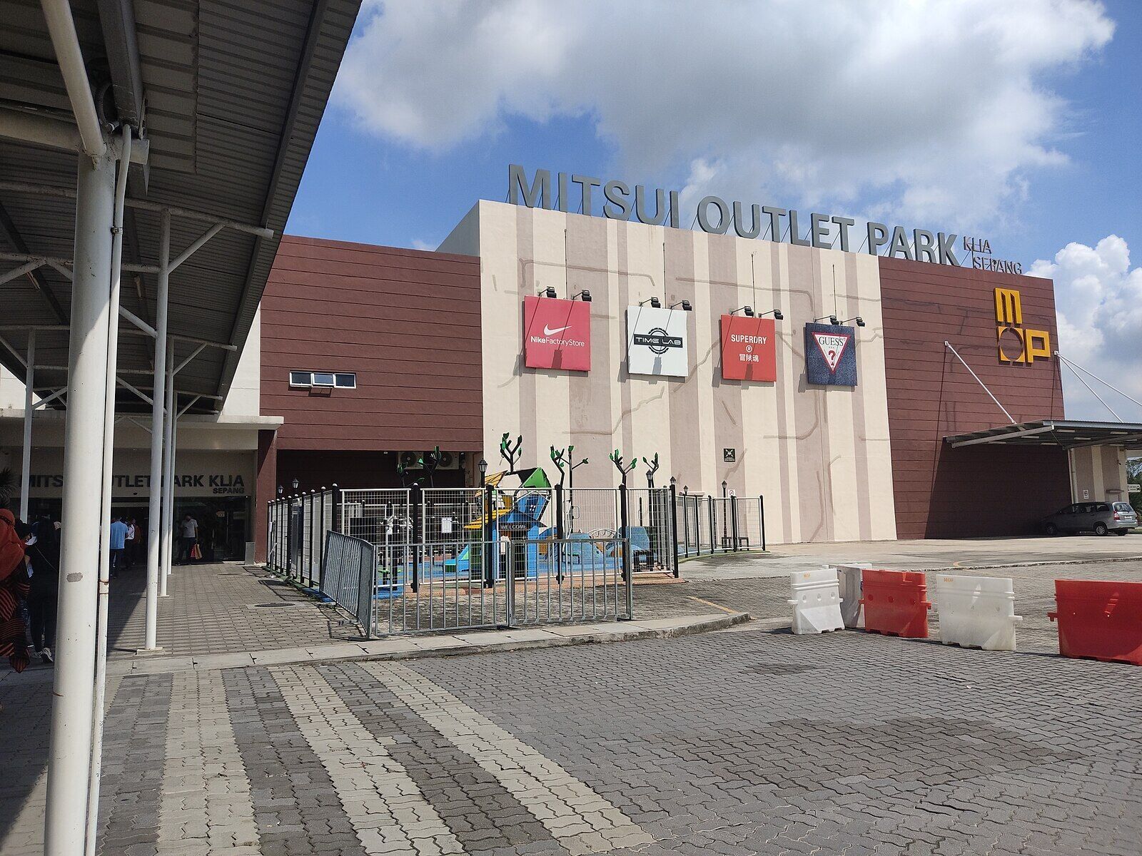 Ein Geschäftsgebäude mit einem Schild, auf dem 'MITSUI OUTLET PARK KIA SERANG' steht.
