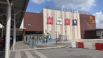 A commercial building with a sign reading 'MITSUI OUTLET PARK KIA SERANG'.