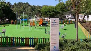 A playground with various equipment, a signboard, and a colorful fence.