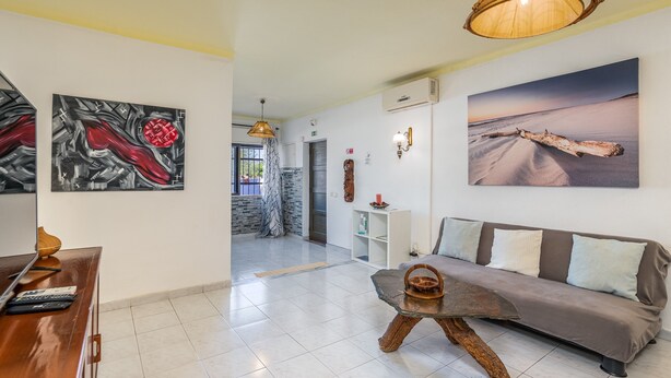 A modern living room with a sofa, a coffee table, and artwork on the walls.