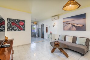 Ein modernes Wohnzimmer mit einer Couch, einem Couchtisch und Kunstwerken an den Wänden.