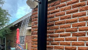 A black vertical water feature attached to a brick wall, with water flowing from a showerhead. - Family Getaway with Huge Private Yard • 5 min to Beach • Peaceful Are (Gulfport)