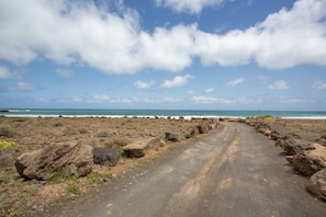 A coastal road with large rocks, leading to the ocean. - Fabi Vacation Apartment with Private Terrace near the Beach (Arrieta)