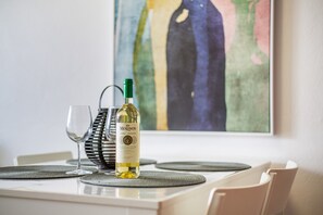 Une table à manger avec une bouteille de vin, un verre à vin et un set de table.