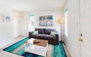 Relax in this stylish living room with a sofa, coffee table, and area rug.