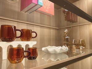 Una exhibición de tazas ámbar sobre un estante blanco en un hotel.