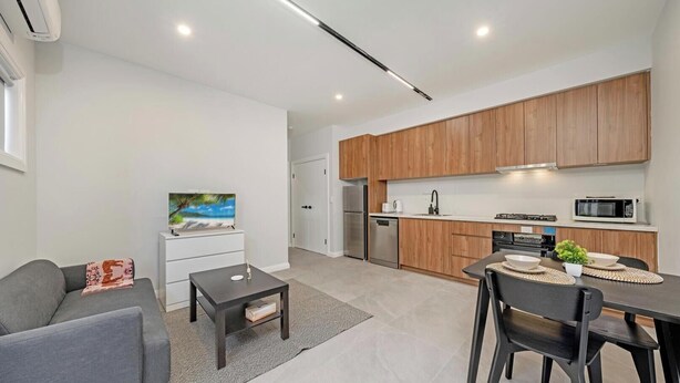 A modern apartment with a living room, kitchen, and dining area.