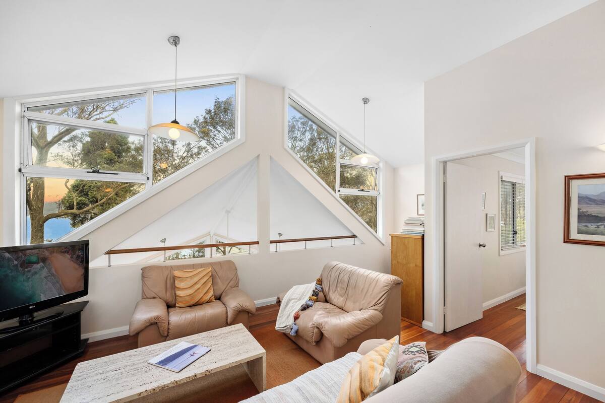A spacious loft with high ceilings, large windows, and a modern interior.