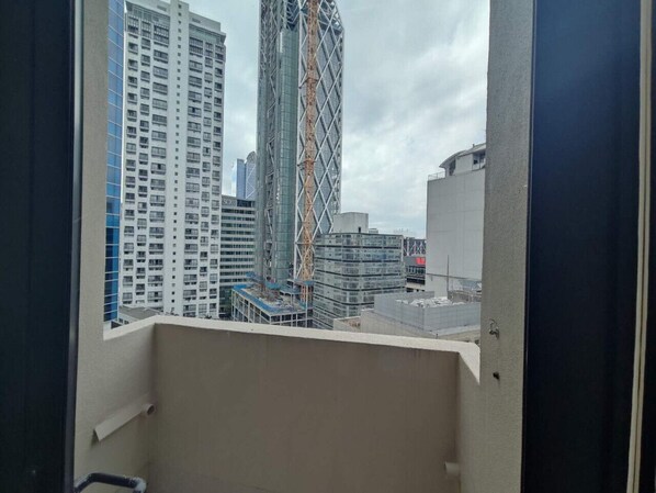 Vista desde un balcón sobre un paisaje urbano con rascacielos y zonas de construcción.