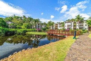 A resort with a water body, a bridge, and lush greenery. - Roomy 2BR Whole-Home Apartment – Pool & 5-Min Walk to Beach (Las Terrenas)