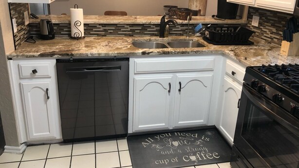 A kitchen with white cabinets, a granite countertop, a dishwasher, a stove, and a backsplash with a mosaic tile design. - Aimee's Retreat on Robinson! Convenient to University of OK in Norman! (Moore)