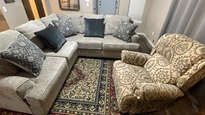 A living room with a sectional sofa, patterned armchairs, a large rug, and a mirror on the wall. - Aimee's Retreat on Robinson! Convenient to University of OK in Norman! (Moore)