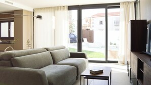 A modern living room with a sofa, a coffee table, and a TV on a wooden cabinet. - Rural house with swimming pool El Huerto del Olivo, Plasenzuela, Trujillo, Cáceres (PLASENZUELA)