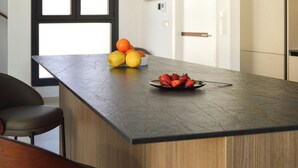 A modern kitchen with a large island, a bowl of fruit, and a plate of strawberries. - Rural house with swimming pool El Huerto del Olivo, Plasenzuela, Trujillo, Cáceres (PLASENZUELA)