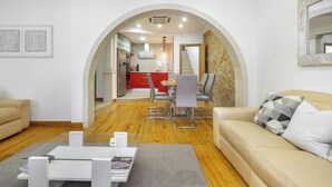 Un salon moderne comprenant un canapé, une table basse et un coin repas avec des chaises et une table.