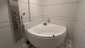 Une salle de bain moderne avec une baignoire sur pieds, une douche et un panneau indiquant qu'il est interdit de fumer.