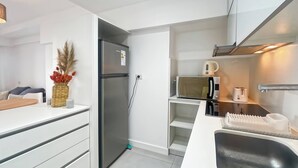 Eine kompakte Küche mit integriertem Kühlschrank, Mikrowelle und Toaster.
