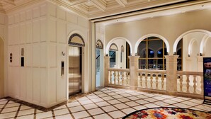 A hotel lobby with a marble floor, an elevator, and a balcony with a railing. - Azure Premium Apartments (Phu Quoc)
