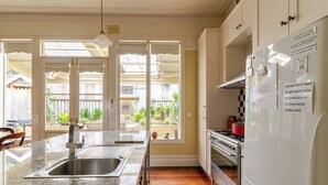 Una cocina con encimera de granito, pileta de acero inoxidable y refrigerador blanco.
